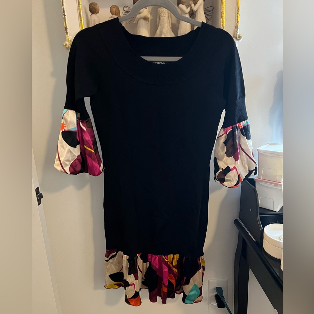 Black stretchy dress that has floral ruffle along the bottom and puffy sleeves.